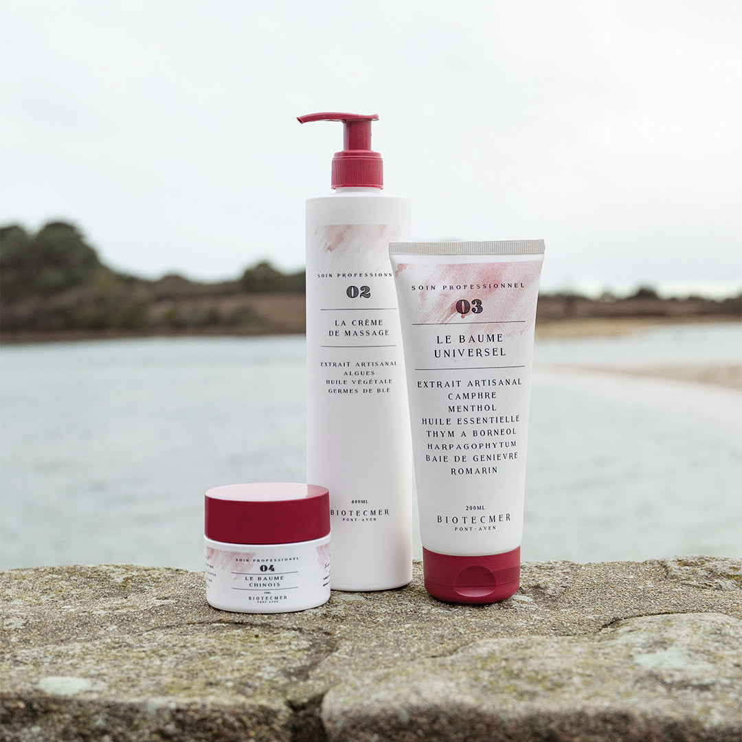 Crème de massage aux algues, baume universel et baume chinois Biotecmer posés sur un rocher en bord de mer en Bretagne